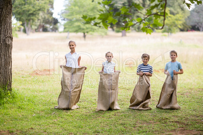 Kids having a sack race in park