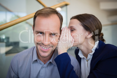 Ã?Â Businesswoman whispering something to her colleague