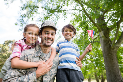 Happy soldier reunited with his son and daughter in park