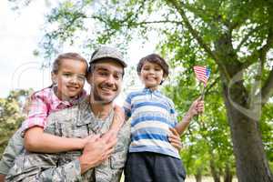 Happy soldier reunited with his son and daughter in park