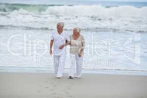 Senior couple walking together on the beach