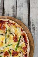 Italian pizza in a chopping board on a wooden plank