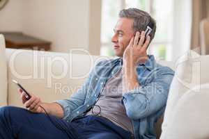 Man listening to music on headphones in living room