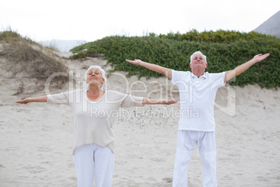 Senior couple standing with arms outstretched