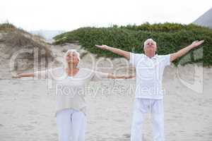 Senior couple standing with arms outstretched