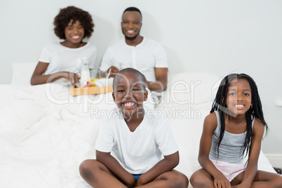Portrait of kids smiling while parents having breakfast in background