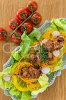 Vegetable salad and cherry tomato on wooden board