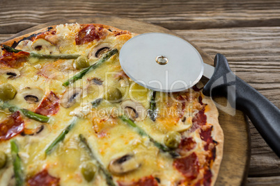Close-up of italian pizza with pizza cutter on a tray