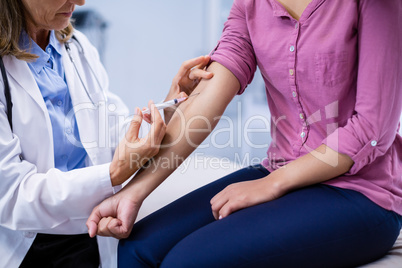 Doctor giving an injection to the patient