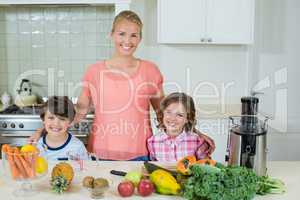 Portrait of a happy mother and his two kids standing in kitchen