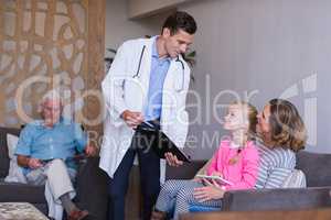 Doctor discussing a medical report with mother and daughter