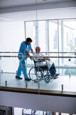 Male doctor interacting with male senior patient in the passageway