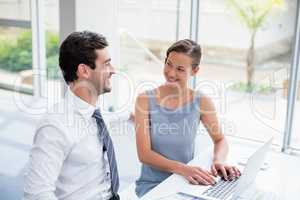 Business executives discussing over laptop