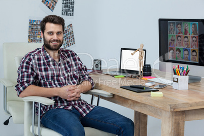 Happy photographer sitting at his desk