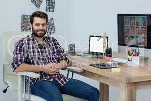 Happy photographer sitting at his desk