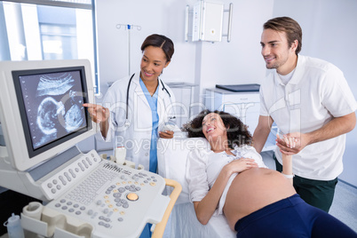 Doctor doing ultrasound scan for pregnant woman