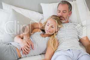 Couple sleeping on bed in bedroom