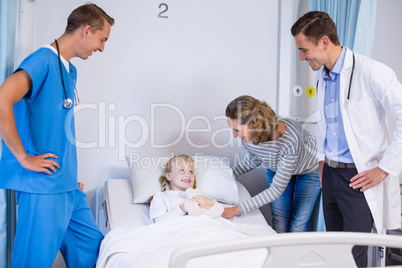 Doctor talking with patient and mother in hospital room