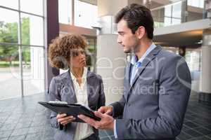 Business executives discussing over clipboard