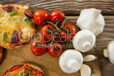 Pizza, tomato, and garlic on a wooden tray