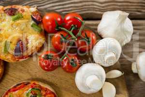Pizza, tomato, and garlic on a wooden tray