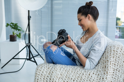 Female photographer reviewing captured photos in her digital camera