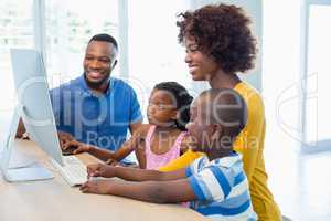 Happy family using computer in living room