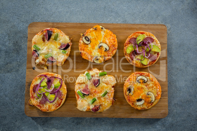 Various pizza arranged on a wooden tray