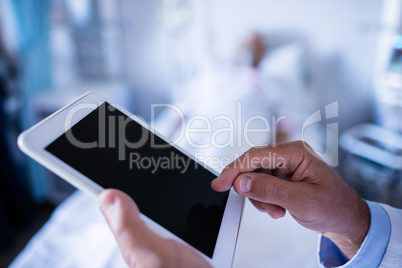 Hands of male doctor using digital tablet