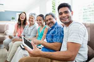 Multi-generation family using digital tablet in living room at home