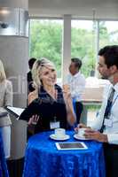 Business executives interacting with each other while having coffee