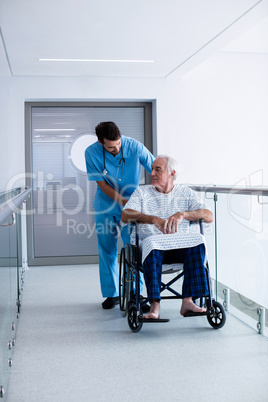 Doctor interacting with male senior patient on a wheelchair