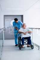 Doctor interacting with male senior patient on a wheelchair