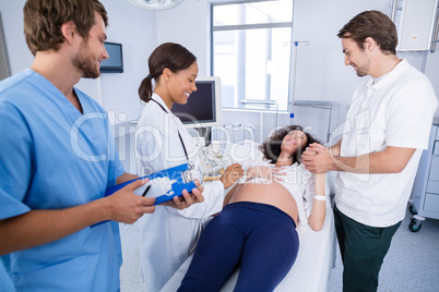 Doctor interacting with pregnant woman while doing ultrasound scan