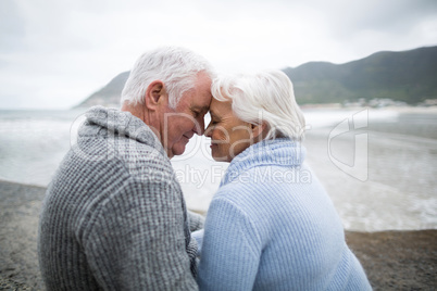 Senior couple sitting on rock at beach