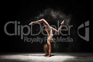 Slender blonde dancing in white dust studio shot