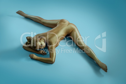 Woman art nude portrait with gold skin shot from above