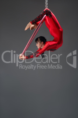 Pretty slim gymnast with red hoop studio shot