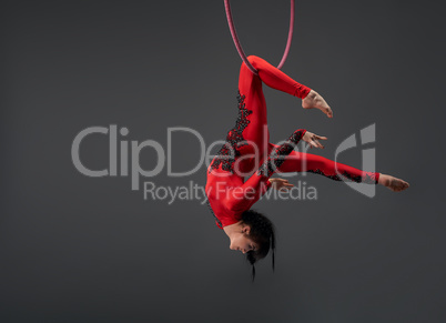 Young slim gymnast with red hoop studio portrait