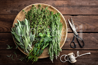 various fresh herbs, rosemary, thyme, mint and sage on wooden background