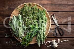 various fresh herbs, rosemary, thyme, mint and sage on wooden background