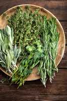various fresh herbs, rosemary, thyme, mint and sage on wooden background