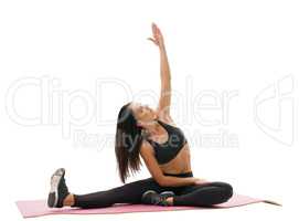 Sporty brunette doing fitness on rug studio shot