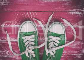 pair of worn sneakers on a pink green old wooden surface