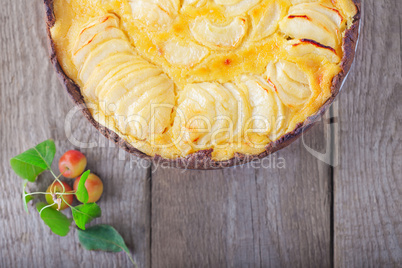 Apple pie with custard on wooden table