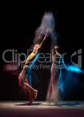 Sporty couple in color dust cloud studio shot