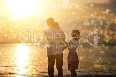 Family enjoying holiday vacation on beach in sunset