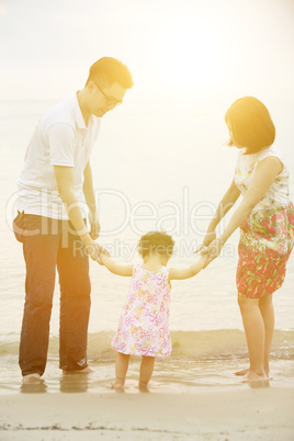 Family holding hands on coastline