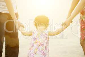 Family holding hands on seaside