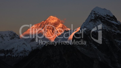 Illuminated peak of Mt Everest at sunset.